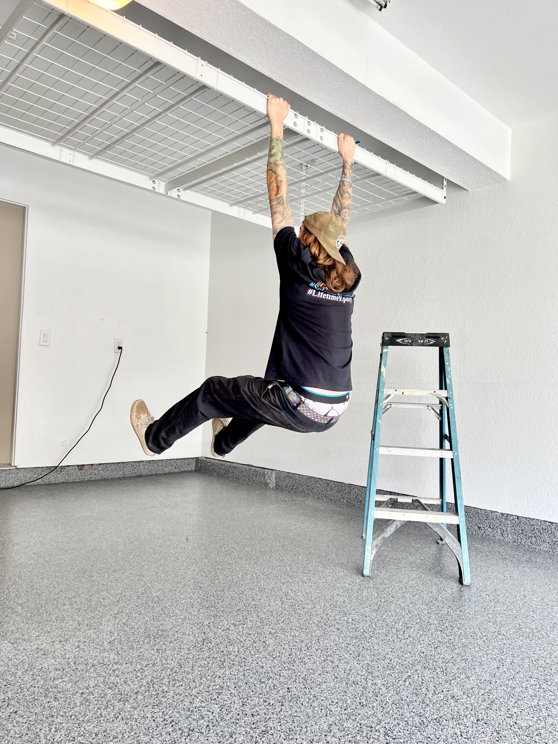 Installer testing the strength of a ceiling storage rack