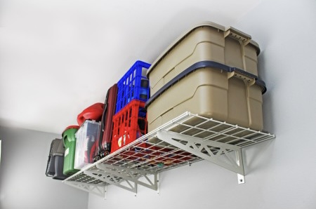 Overhead storage rack holding totes and luggage