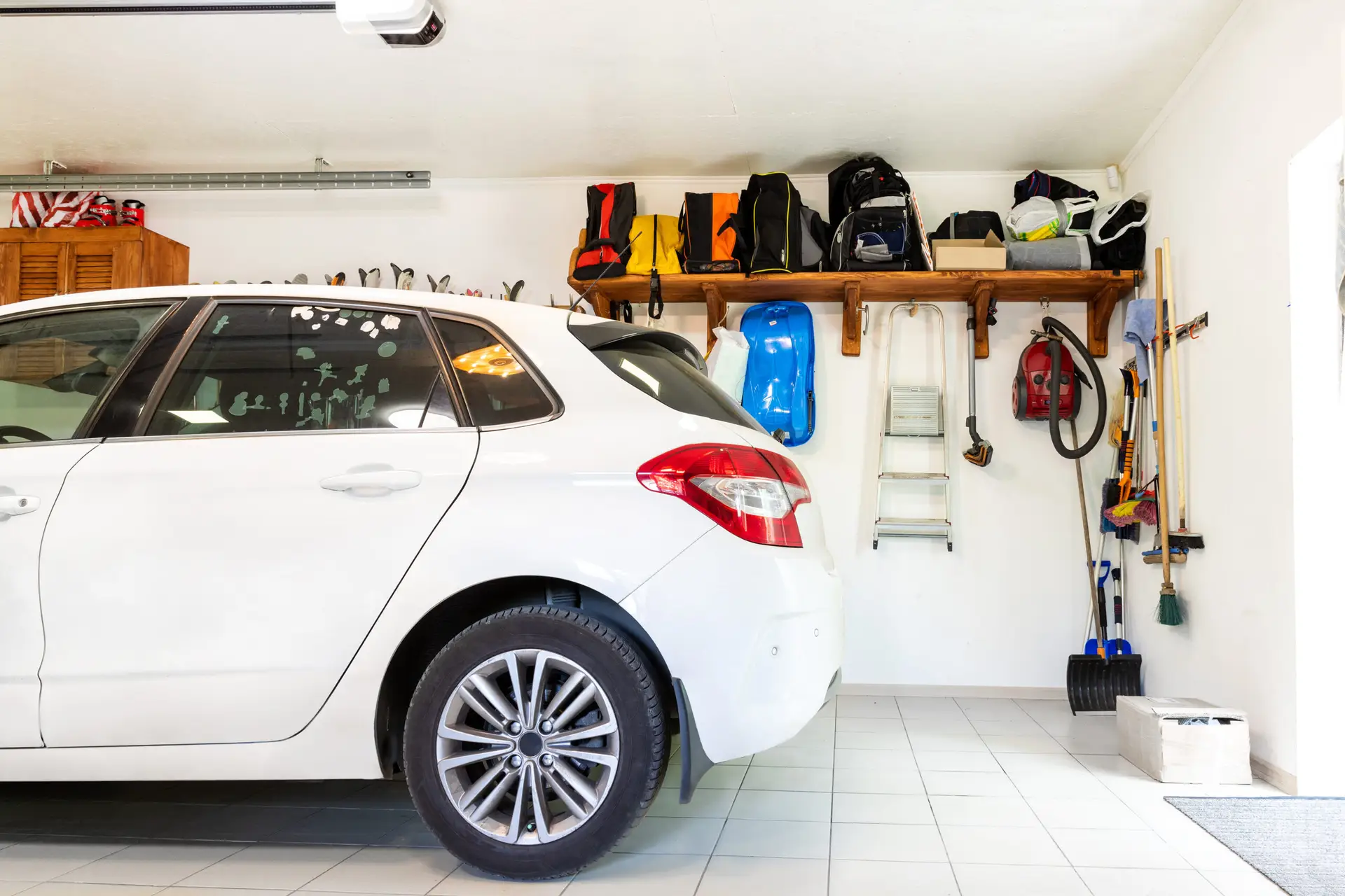 Coastal polyaspartic vs epoxy: a car parked in a clean San Diego garage with a coated floor and wall storage